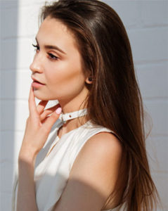 A young woman wearing a white shirt and a choker-Hair Transplant in Chennai