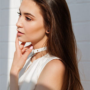 A young woman wearing a white shirt and a choker-Hair Transplant in Chennai