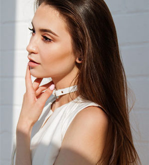 A young woman wearing a white shirt and a choker-Hair Transplant in Chennai